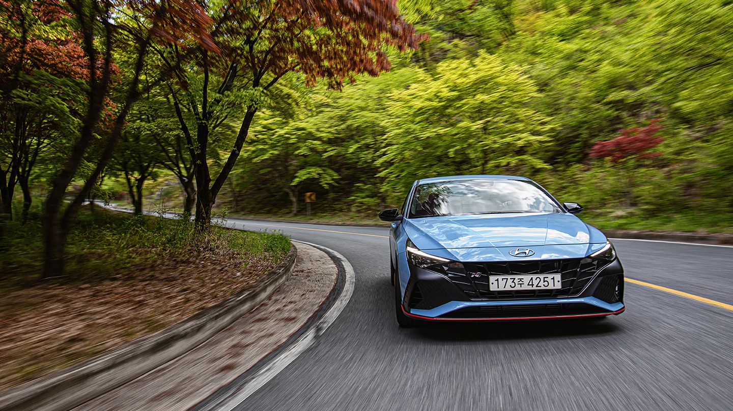 Front view of Elantra N driving through a dense forest road