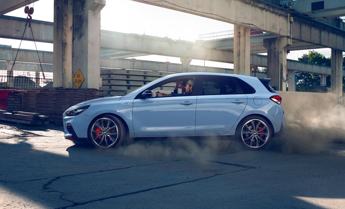 A driver and passenger with playful expressions are driving in an i30 N vehicle.