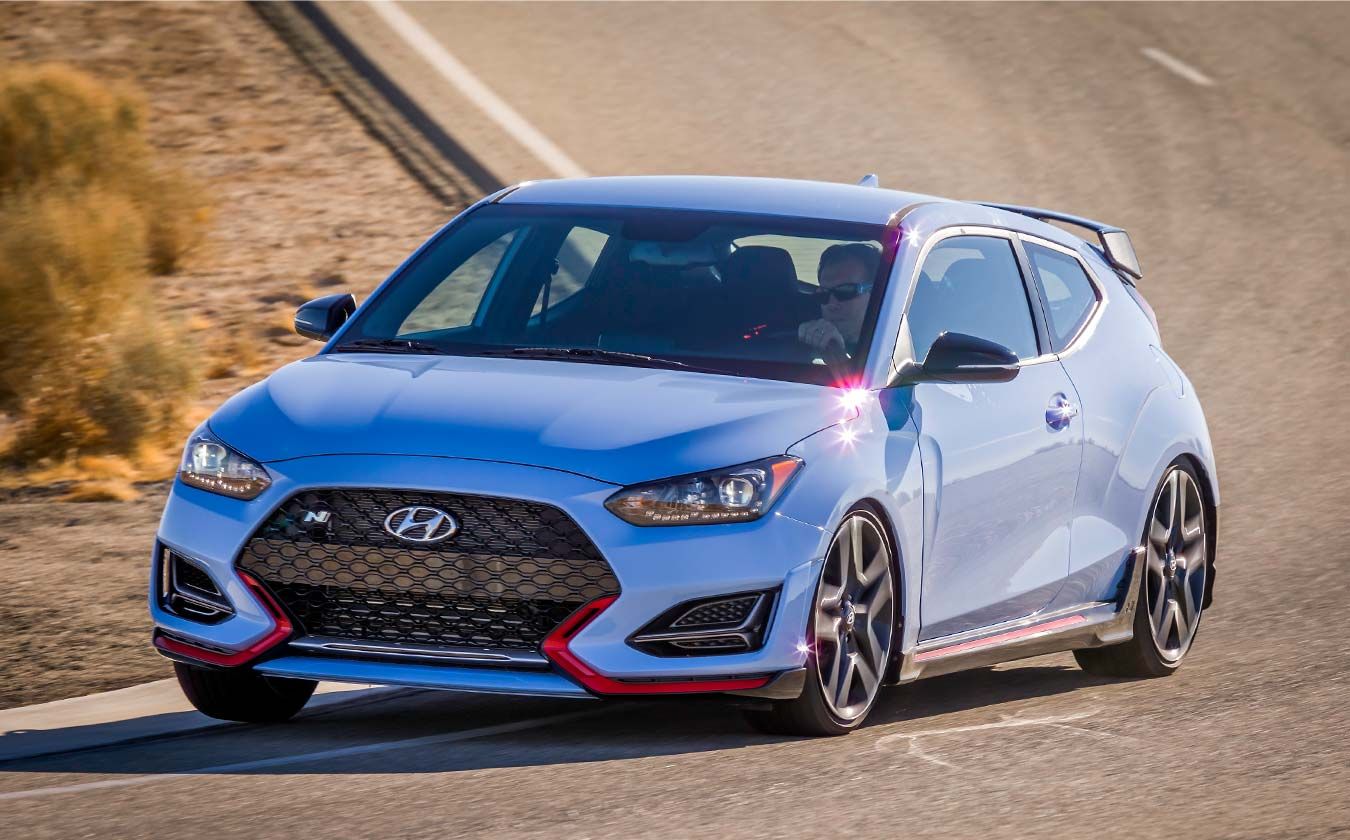 N vehicle driving on the circuit with grass visible on the left side.