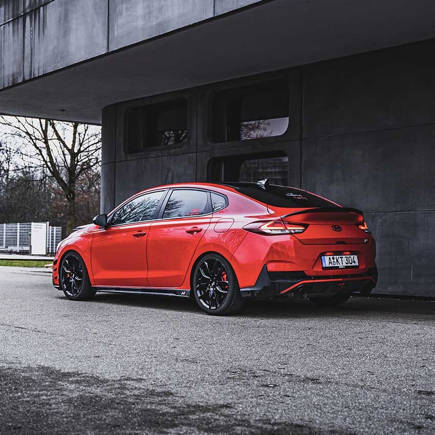 The side view of the i30 N vehicle parked next to the building.