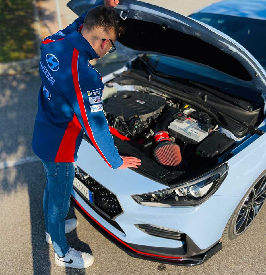 A man inspecting the i30 N with the hood open.