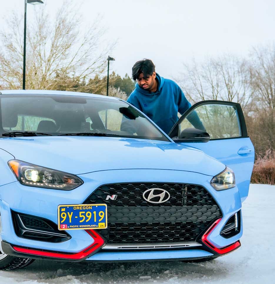 A man opening the driver’s side door of the car.
