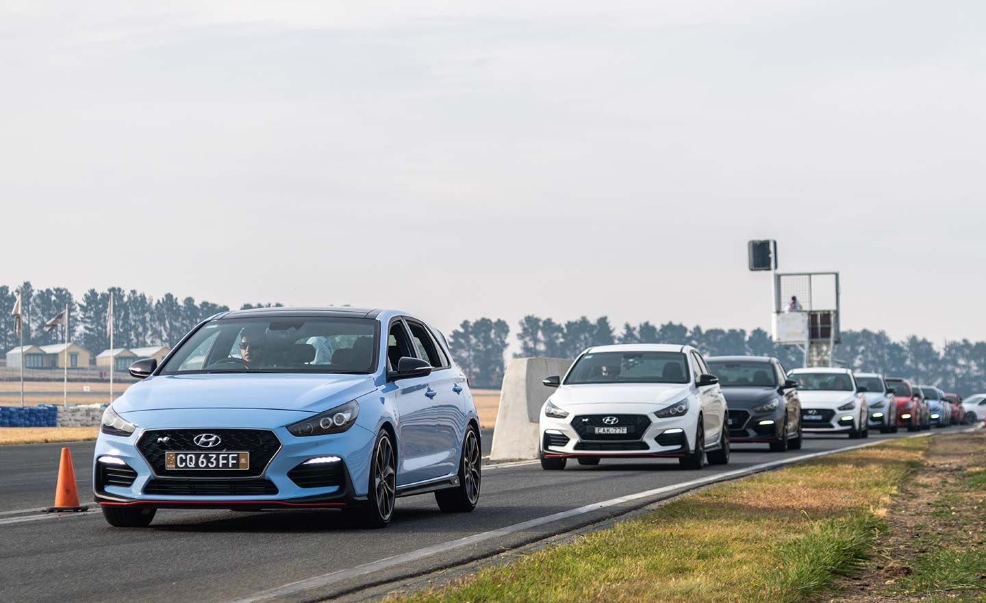 Vehicles participating in the track day driving on the road.