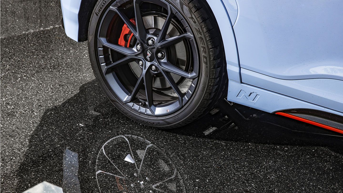 Kona N’s tire reflecting on the asphalt road.