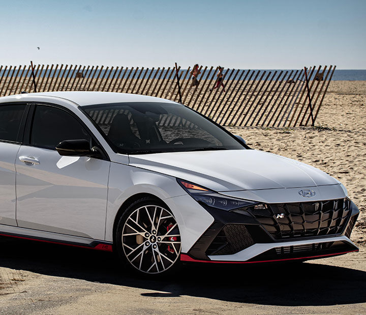 The side of a car parked on the sand is visible