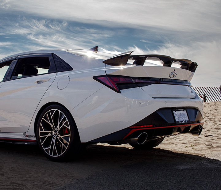 The rear of the car is visible, parked on the sand