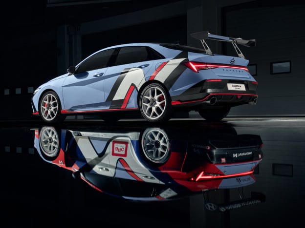 A photo showing the left side of the Elantra N TCR Edition, and the Elantra TCR Edition decal installed on the car reflected like a mirror on the floor.